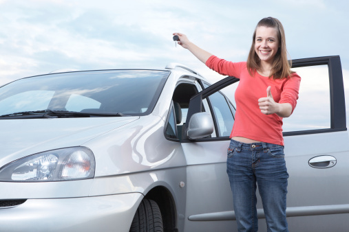Teenage girl holding keys of new car