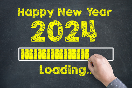 Close up of Human hand Drawing Innovation Technology Loading New Year 2024 on Blackboard Background