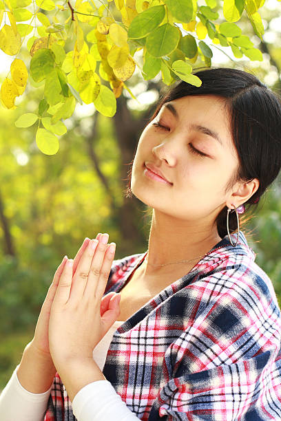 istock lovely young woman is praying 182199396