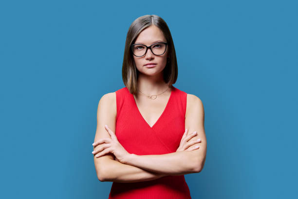 istock Young serious confident woman in red on blue studio background 1821996157