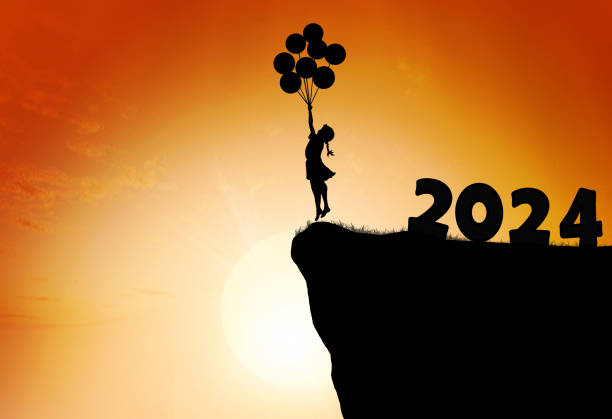 silhouette of kid jumping playing on mountain with air balloons at sunset. New year 2024. silhouette of kid jumping playing on mountain with air balloons at sunset. New year 2024. child freedom and education concept nature calendar stock pictures, royalty-free photos & images