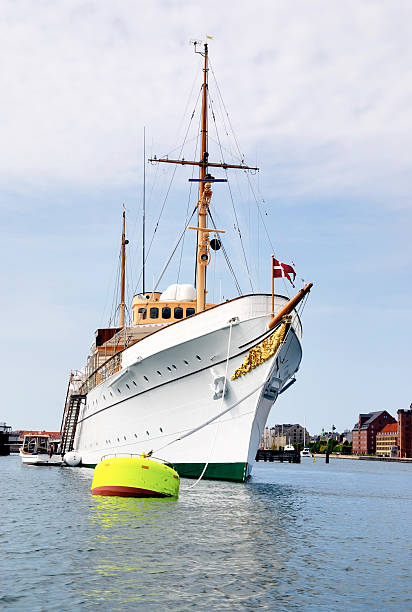 The royal yacht Dannebro is moored in Copenhagen harbor (Denmark). The photograph was taken during a boat trip in the harbor. The ship was build in Copenhagen and launched in 1932. It is designed by N. K. Nielsen. The boat is used by the Regent and her family and it has been to Greenland and the Faroe Islands.