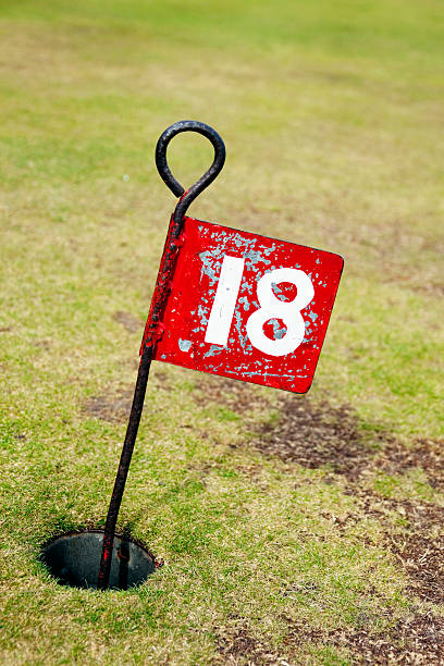 istock No 18 - flag in hole on putting green 182201813