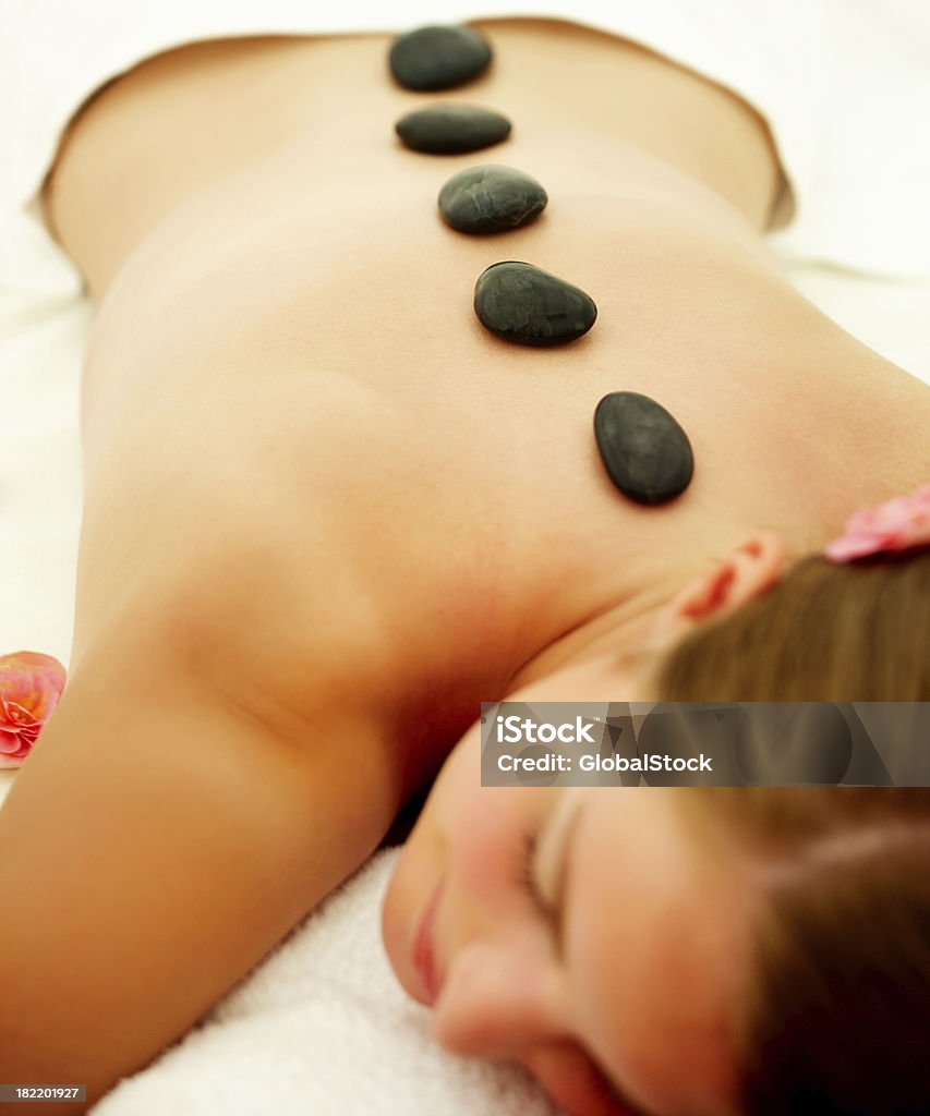 Молодая женщина, получать лечение горячими камнями в спа-центре - Стоковые фото 20-24 года роялти-фри