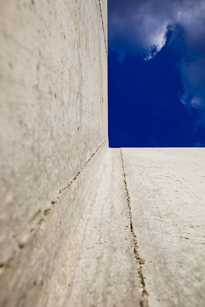 istock Concrete Foundation Wall Looking Up To Blue Sky with Clouds 182202530