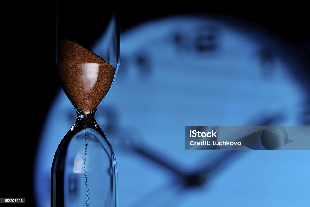 Hourglass Hourglass against a blue clock Antique Stock Photo