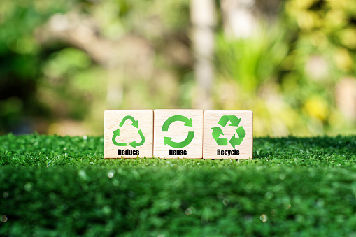 Metal, plastic, glass and paper waste inside green recycle symbol.