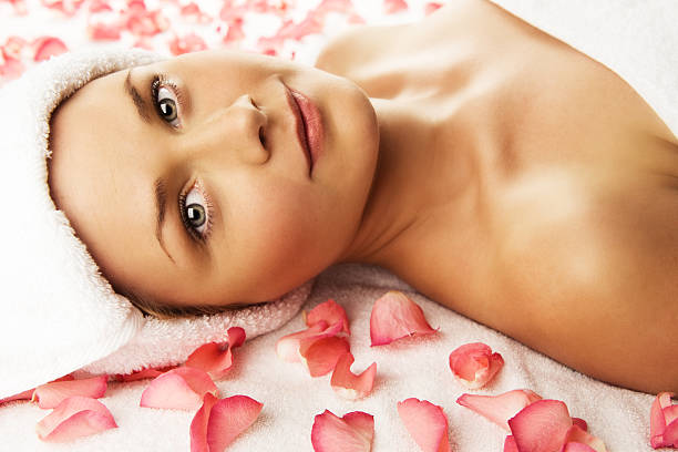 istock Woman lying on a towel with rose petals 182203491