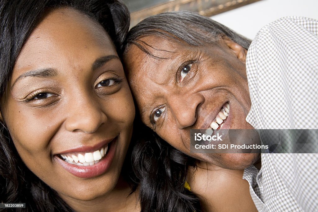 Felice giovane donna abbracciare sua nonna - Foto stock royalty-free di Ambientazione interna