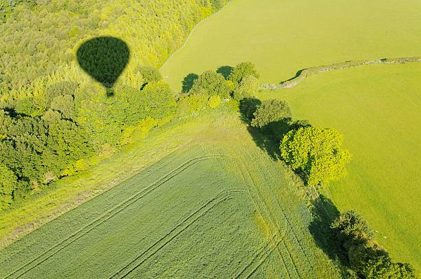 Black and white - Shadow of hot air balloon over freshly cut alfalfa field seen from aerial viewpoint in Menifee southern California United States