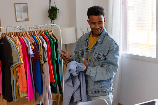 istock african american fashion designer using smartphone while standing near rack with clothes 1822041618