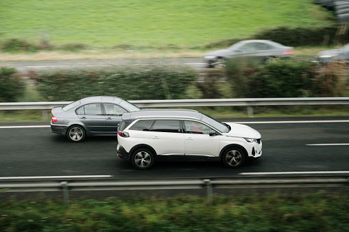 Santander, Spain - 29 November 2023:A car overtaking another car in motion on a highway