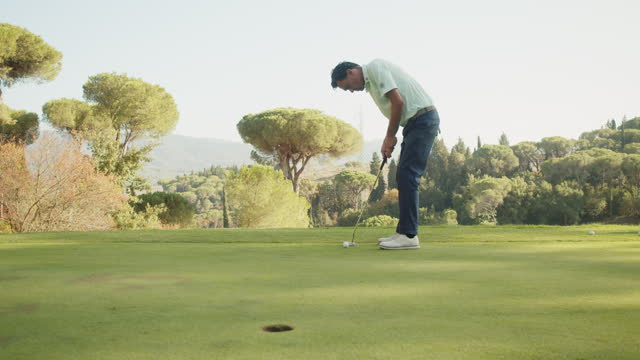 A golf player is putting on green