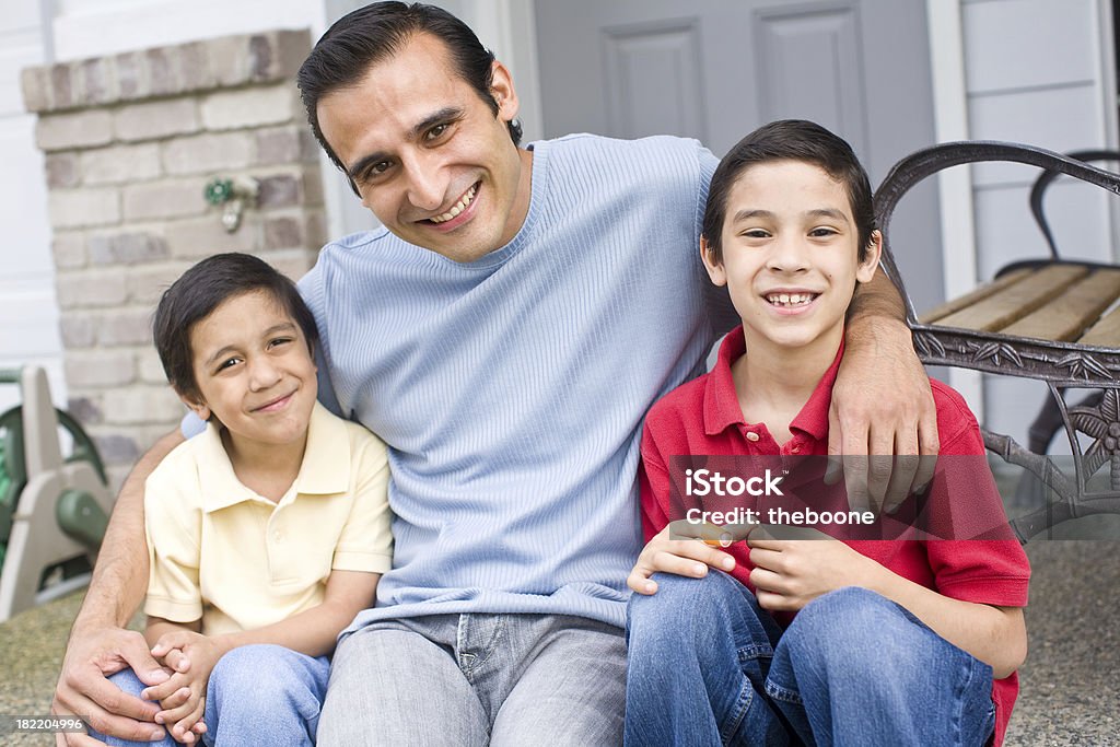Giovani ispanici padre seduto all'aperto con il suo ragazzo - Foto stock royalty-free di 6-7 anni