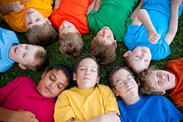 istock Group of Young Boys Relaxing and Sleeping in the Grass 182205491