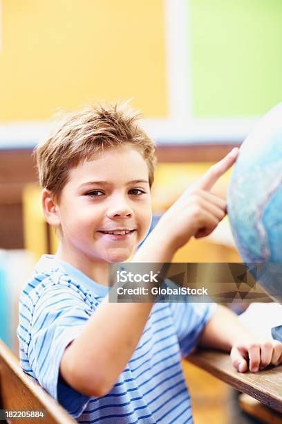 Happy Little Boy With El Dedo En Un Mundo Foto de stock y más banco de imágenes de 8-9 años - 8-9 años, Aprender, Color - Tipo de imagen