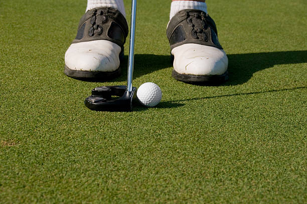 istock Golfer putts ball on green 182205972