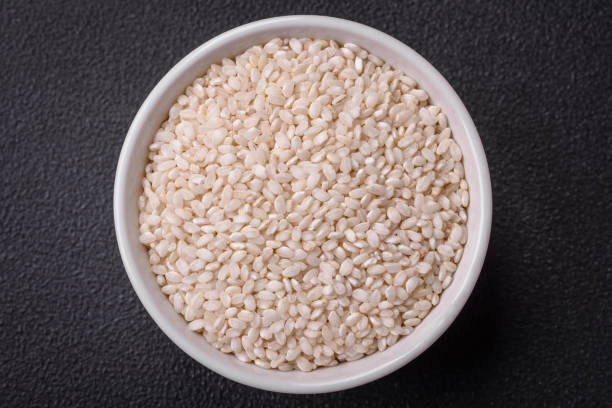 istock White uncooked rice in a round ceramic bowl on a dark concrete background 1822072917