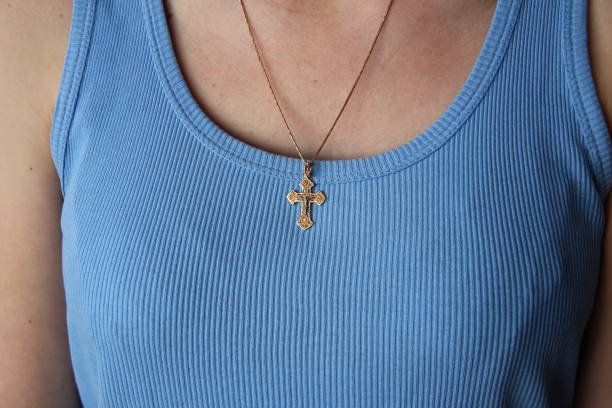 croix d’or sur une chaîne sur la poitrine d’une femme - breast cleavage women diamond photos et images de collection