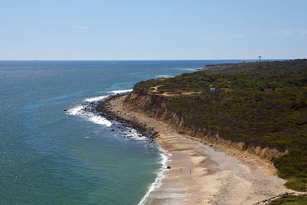 Atlantic Ocean Beach and Cliffs "The Atlantic ocean, with steep cliffs and sandy beach. This is the sea cliffs area of Camp Hero State Park, located in Montauk, Long Island, New York, USA, as seen from high atop Montauk Lighthouse. Montauk is a popular summer travel destination.Reference RAW image 417 taken by John Archer on September 20, 2009." montauk point stock pictures, royalty-free photos & images