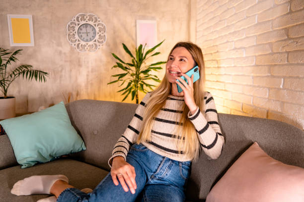 istock A young woman talking on the phone while enjoying at home 1822078212