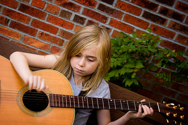 Menina tocando violão - foto de acervo