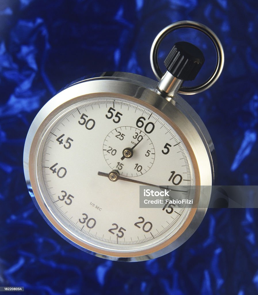 stopwatch stopwatch  with warm light reflections photographed on a blue background  mottled and defocused. Stopwatch Stock Photo