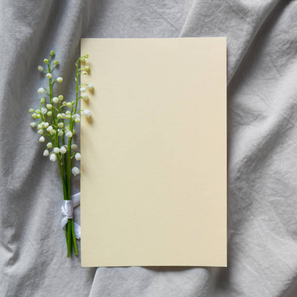 istock Blank greeting card, invitation and envelope mockup. Minimal floral frame made with a bouquet of white lilies of the valley. Flat lay, top view. Happy mother's day, women's day or birthday, wedding 1822080859