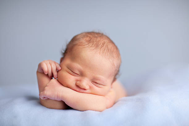 istock Newborn Baby Boy Sleeping Peacefully on Blue Blanket 182208792