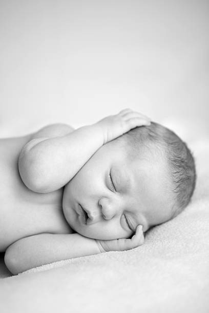 istock Newborn Baby Sleeping Peacefully on Side 182209194