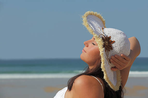 istock Young woman with white sun hat tanning on beach 182210093