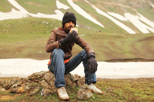 An Asian backpacker tourist having morning tea at Ratti Gali/Pass in Northern areas Pakistan.+++ shot before 1 sep *****
