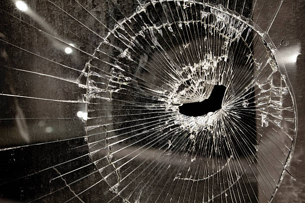 割れガラスの窓でたビジネスの不況 - bullet hole glass cracked hole ストックフォトと画像