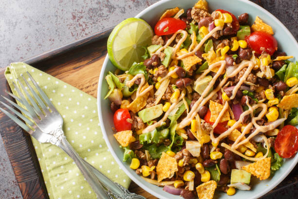 istock Beef Taco Salad made with beans, corn, nacho chips, lettuce, tomato, onion, cheese and avocado closeup on the plate. Horizontal top view 1822105806