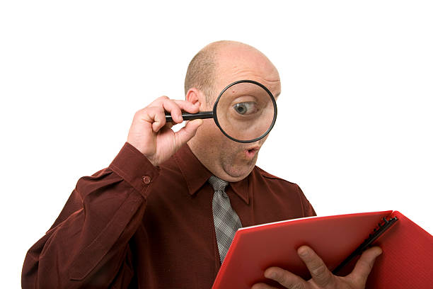 Reading Magnified "A man reads the fine print, eye magnified." read the fine print stock pictures, royalty-free photos & images