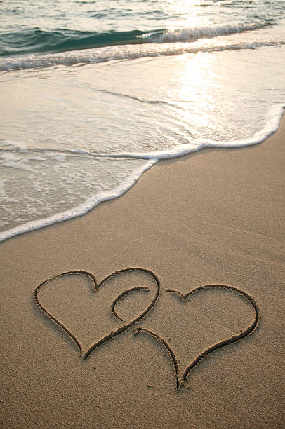 istock Sand Hearts Intertwined on Sunset Beach 182212066