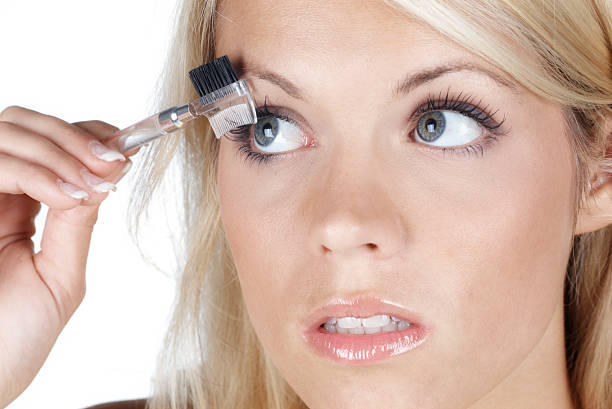 istock beautiful blonde woman brushing her eyelash 182212837