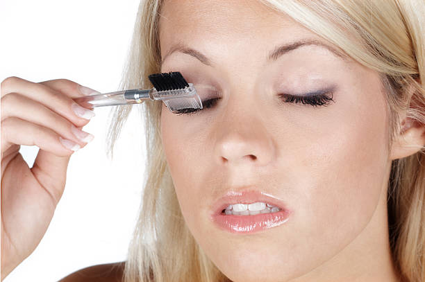 istock beautiful blonde woman brushing her eyelash 182212838