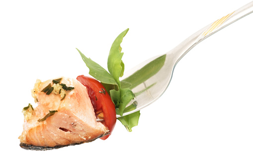 Salmon meat with rucola and tomato on fork