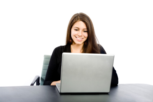 A beautiful woman sits with a laptop and smiles.