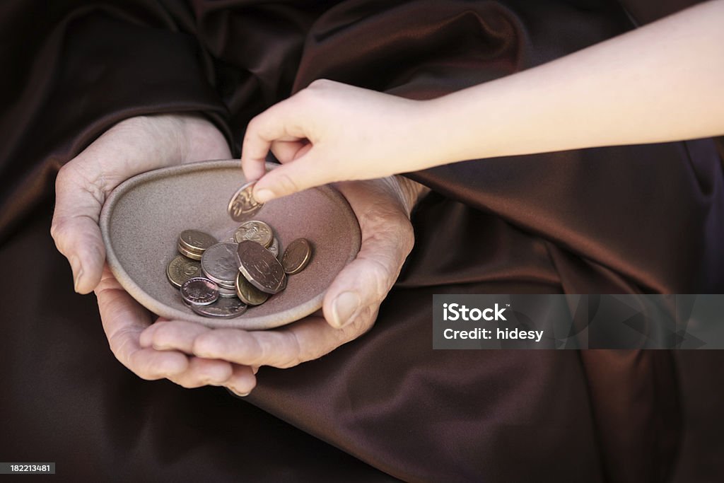 Children's Charity Childs hand putting coin in charity bowl Assistance Stock Photo
