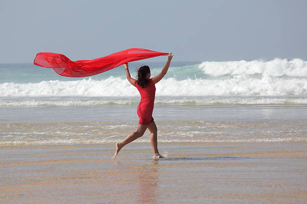 istock Woman running on beach holding red scarf in wind (XXXL) 182213806