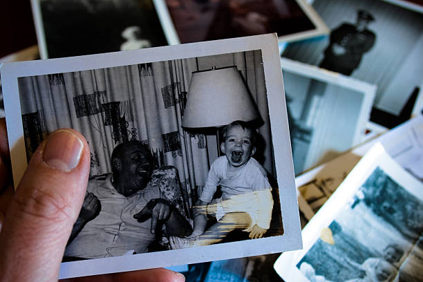 Hand holds Vintage photograph of 1960s father and child stock photo