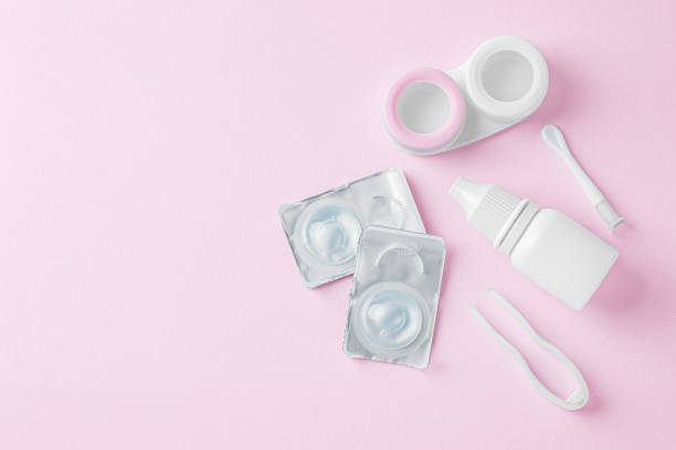 istock Contact lenses with container, eye drop and tweezer on pink background, top view 1822147149
