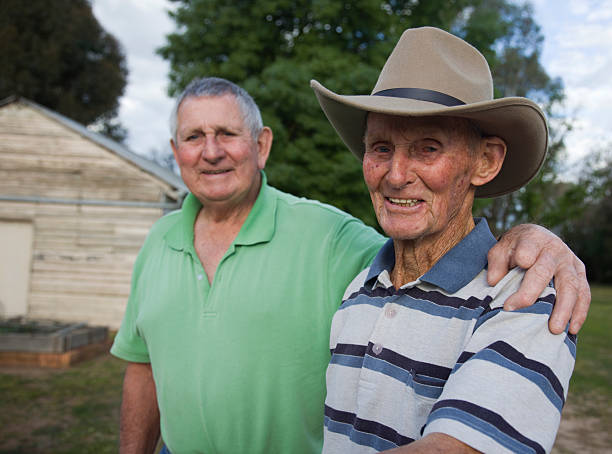 An elderly man and his younger brother standing outside stock photo