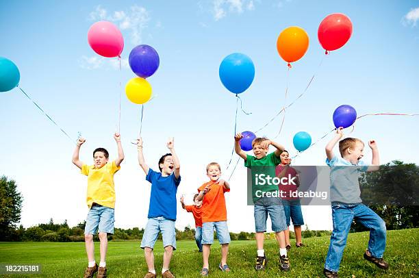 Gruppo Di Felici Ragazzi Saltare E Celebrare Esterno - Fotografie stock e altre immagini di Palloncino a elio