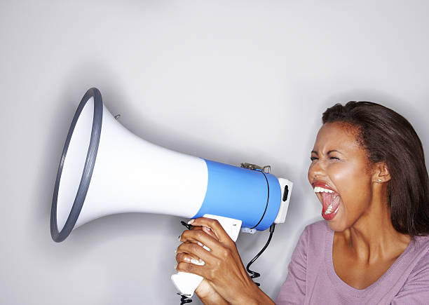 istock Young woman yelling into a bullhorn 182215488