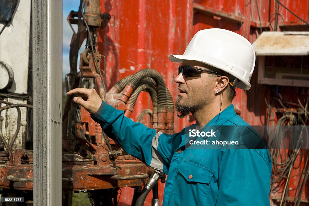 Driller at drill floor Driller at drill floor showing something on the kelly. Oil Field Stock Photo