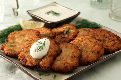 Freshly made potato latkes, with cultured sour cream, dill, and lemon.