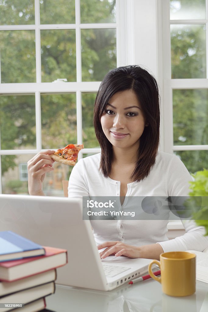 Giovane donna asiatica che lavora e mangia Pizza Vt - Foto stock royalty-free di 20-24 anni